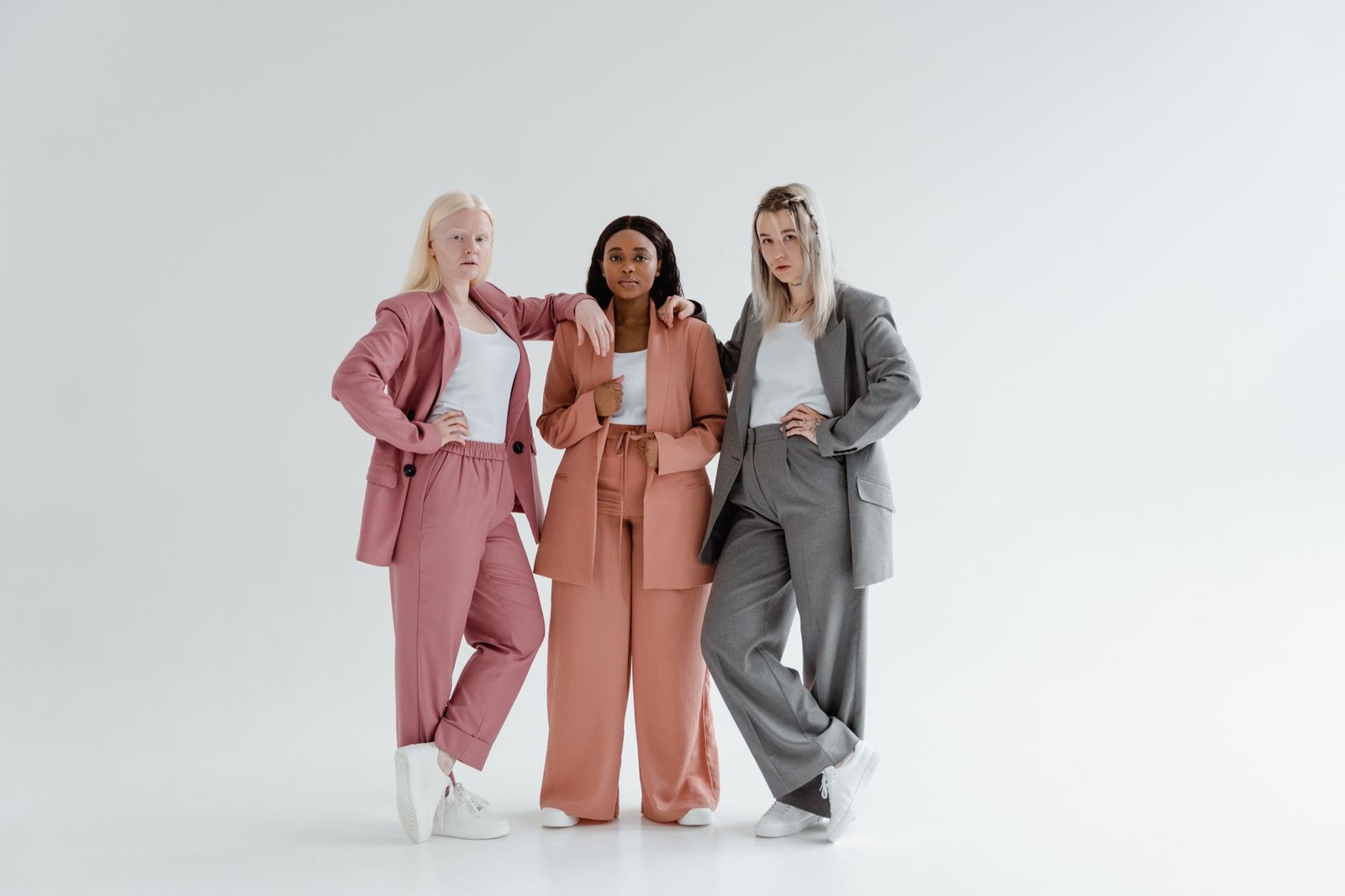 Three women posing in modern business suits highlighting diversity and leadership.