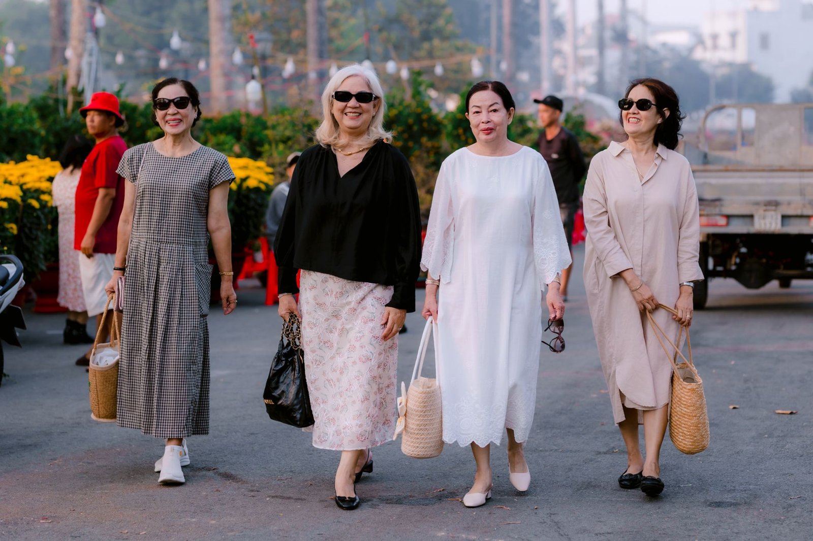 Four fashionable women strolling outdoors, exuding confidence and joy.