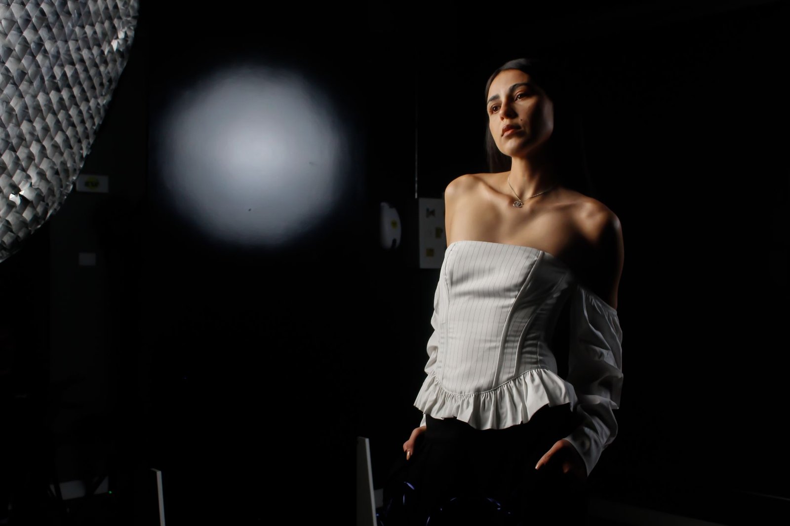 Studio portrait of a woman with dramatic lighting creating a moody atmosphere.