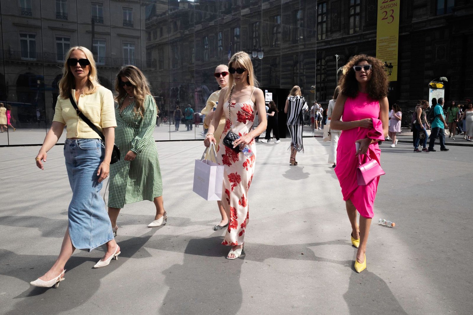 Group of stylish women walking in the city showcasing vibrant summer fashion.