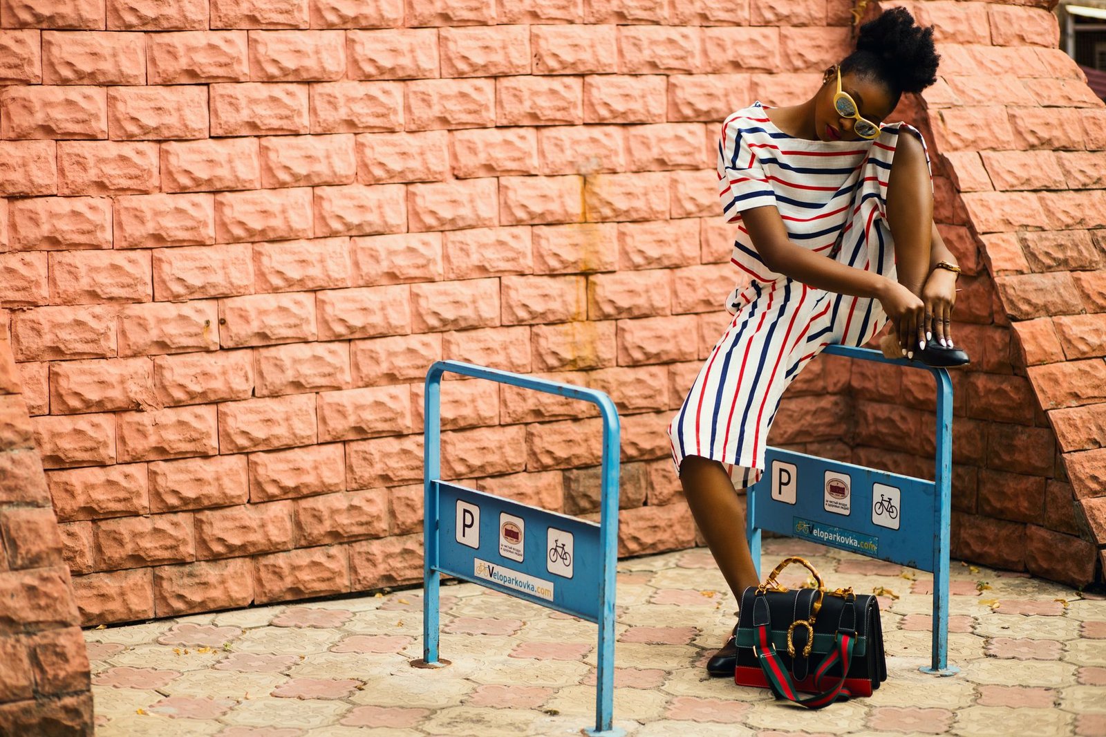 Stylish woman in striped dress posing outdoors in Kharkiv, Ukraine.