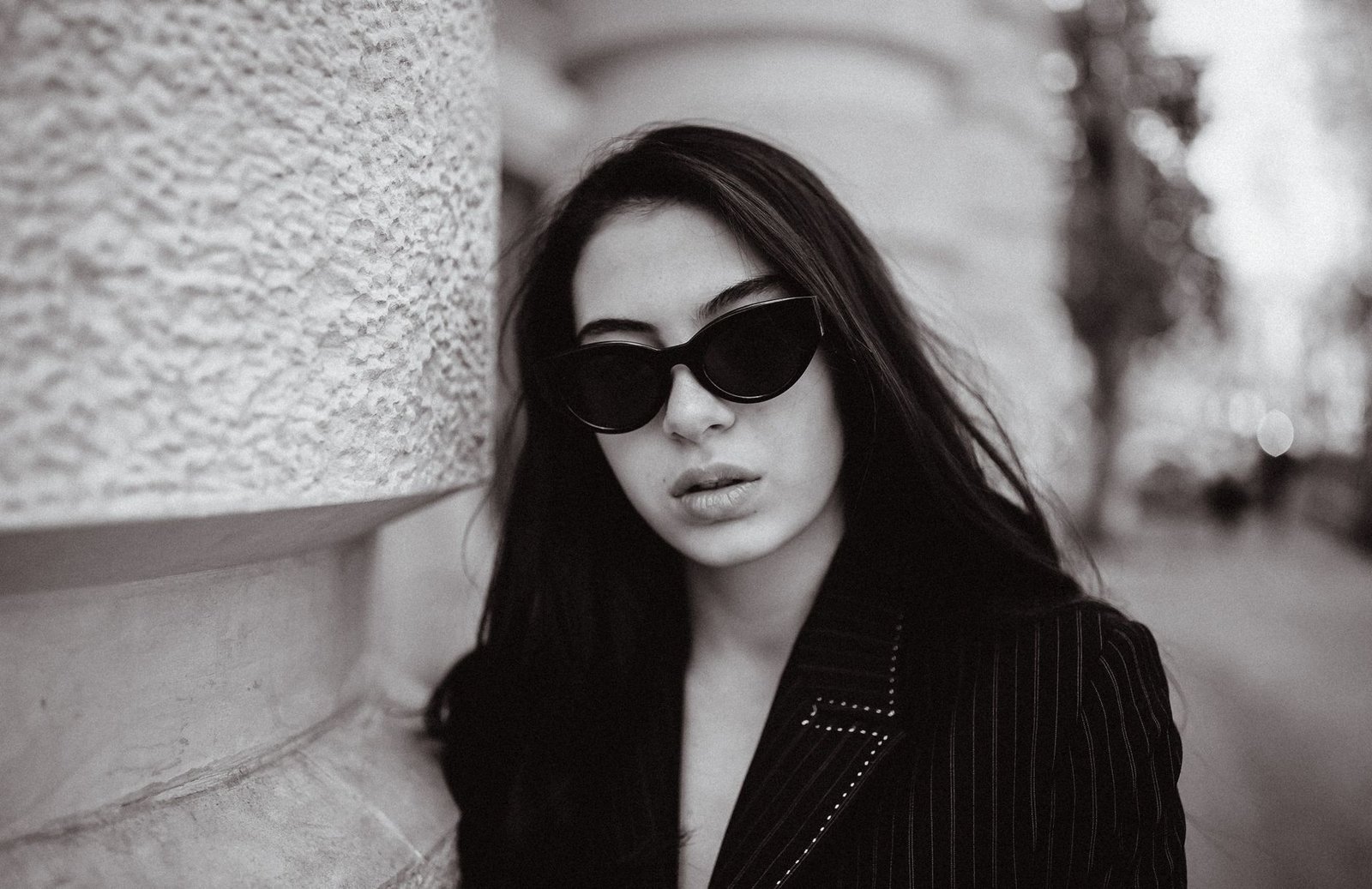 Stylish monochrome portrait of a woman in sunglasses, highlighting bold fashion vibes.