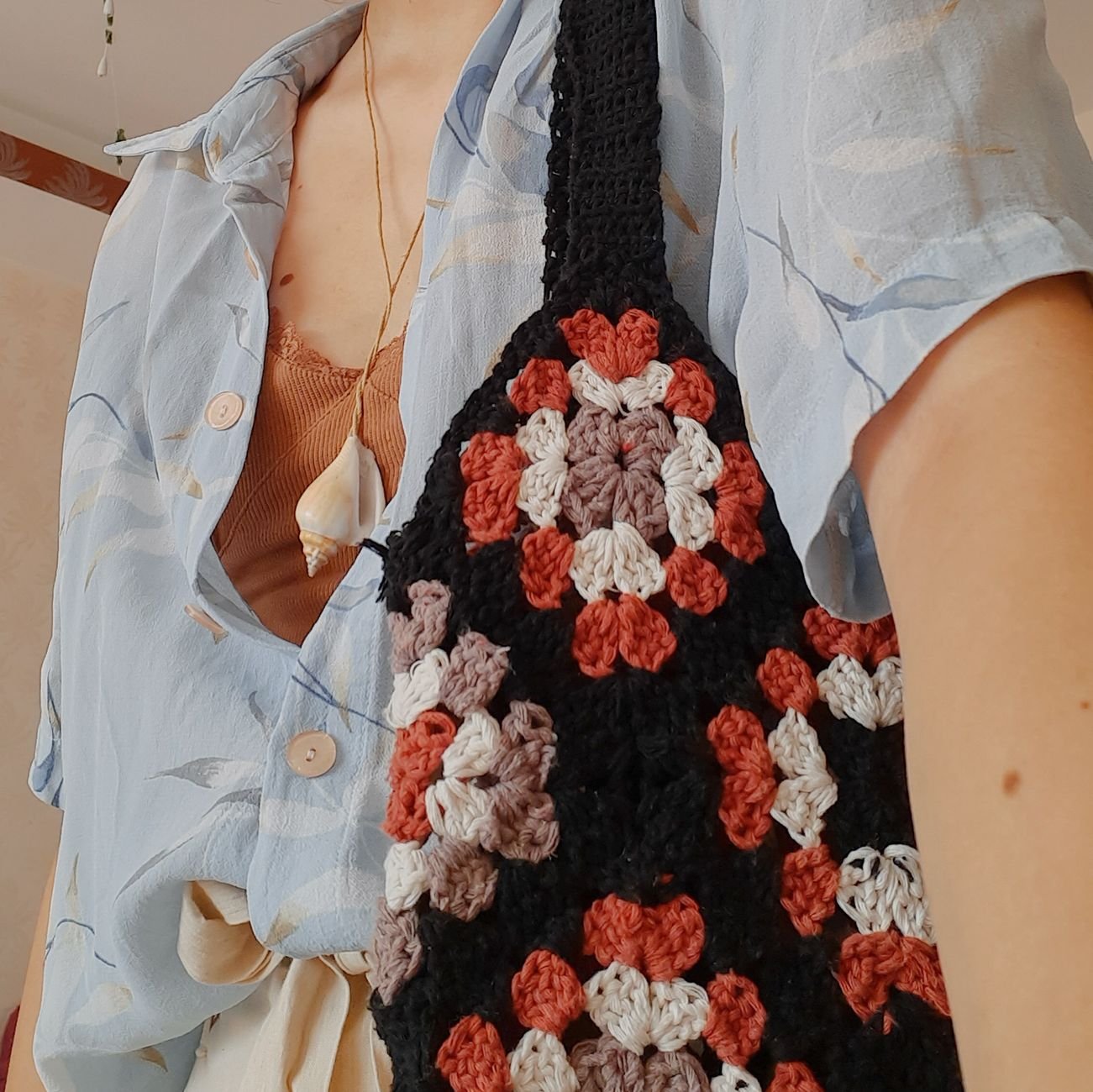 Close-up of a stylish knitted bag paired with a casual summer outfit, showcasing fashion trends.