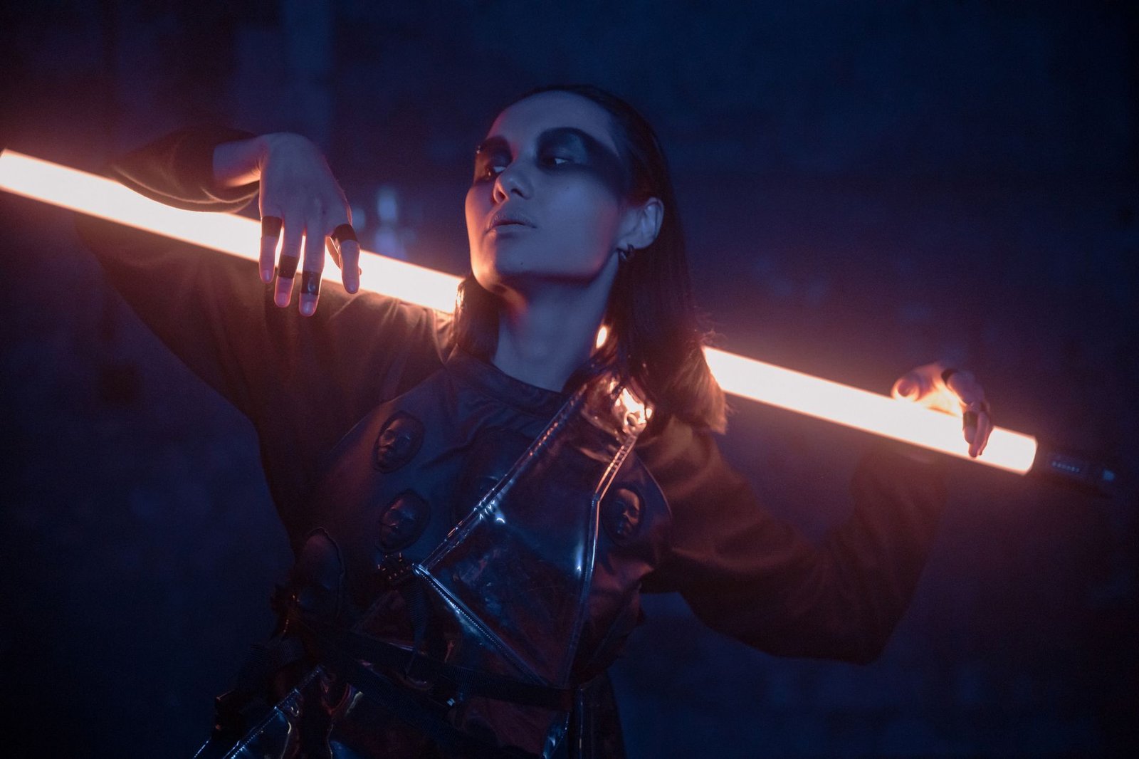 Striking portrait of a woman in cyberpunk fashion, illuminated by neon light.