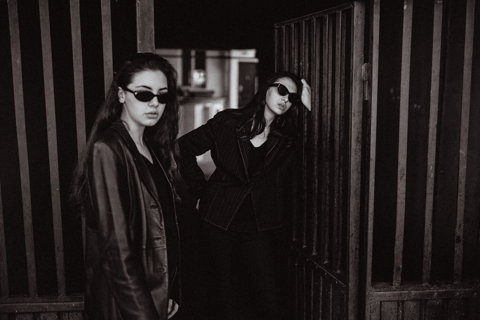 Stylish monochrome portrait of two women in sunglasses, exuding a noir fashion vibe.