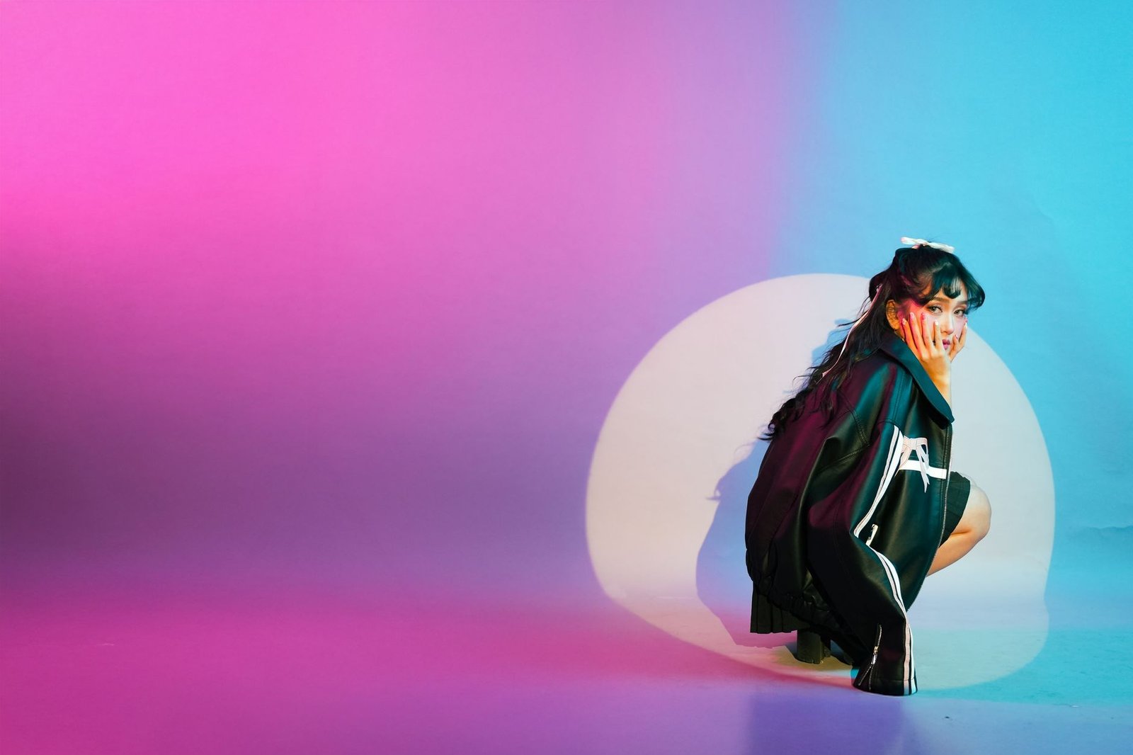 Vibrant studio portrait featuring a young woman surrounded by colorful lighting effects.