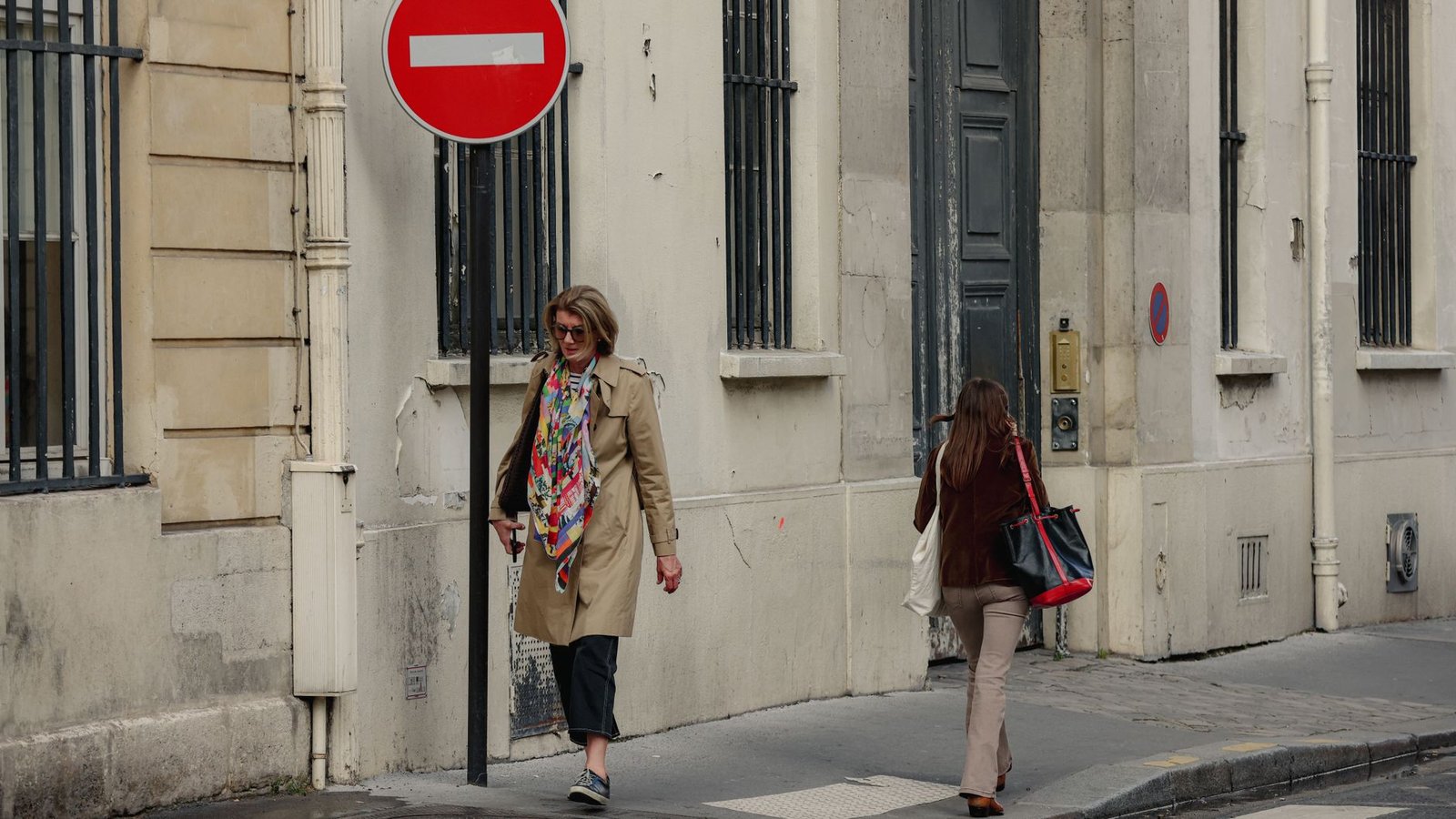 Urban street scene in Paris, Île-de-France, with two women walking and a no entry sign in view.