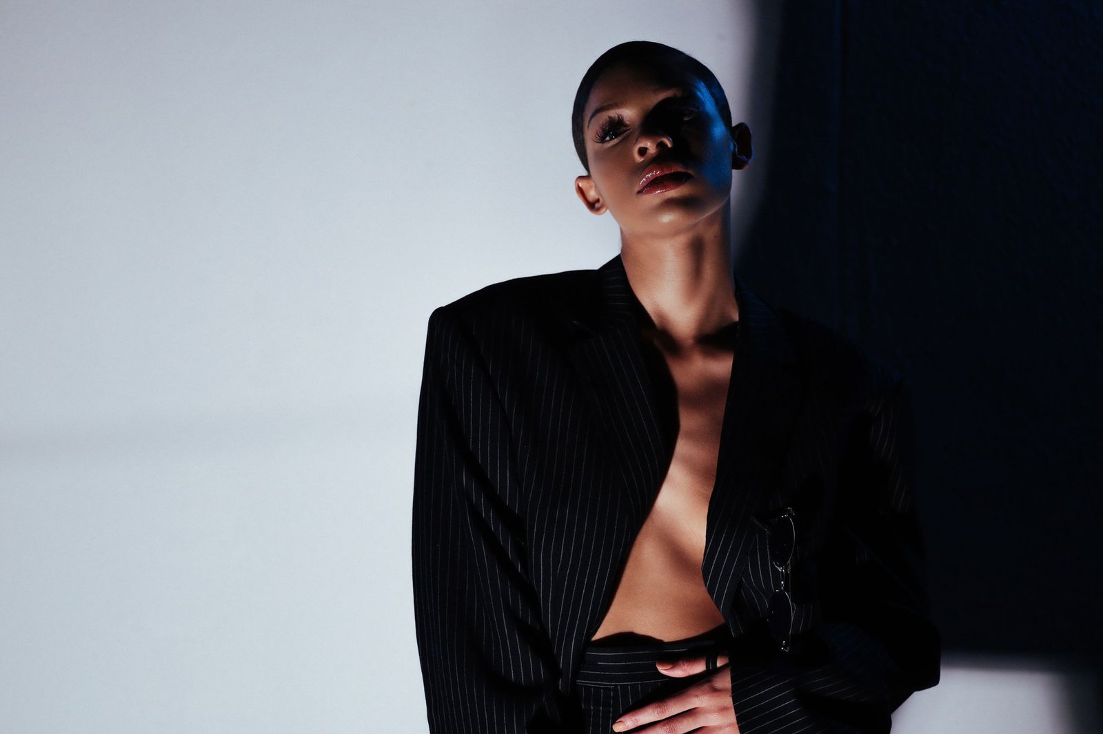 Elegant fashion model posing in a stylish studio shoot with dramatic lighting and modern style.
