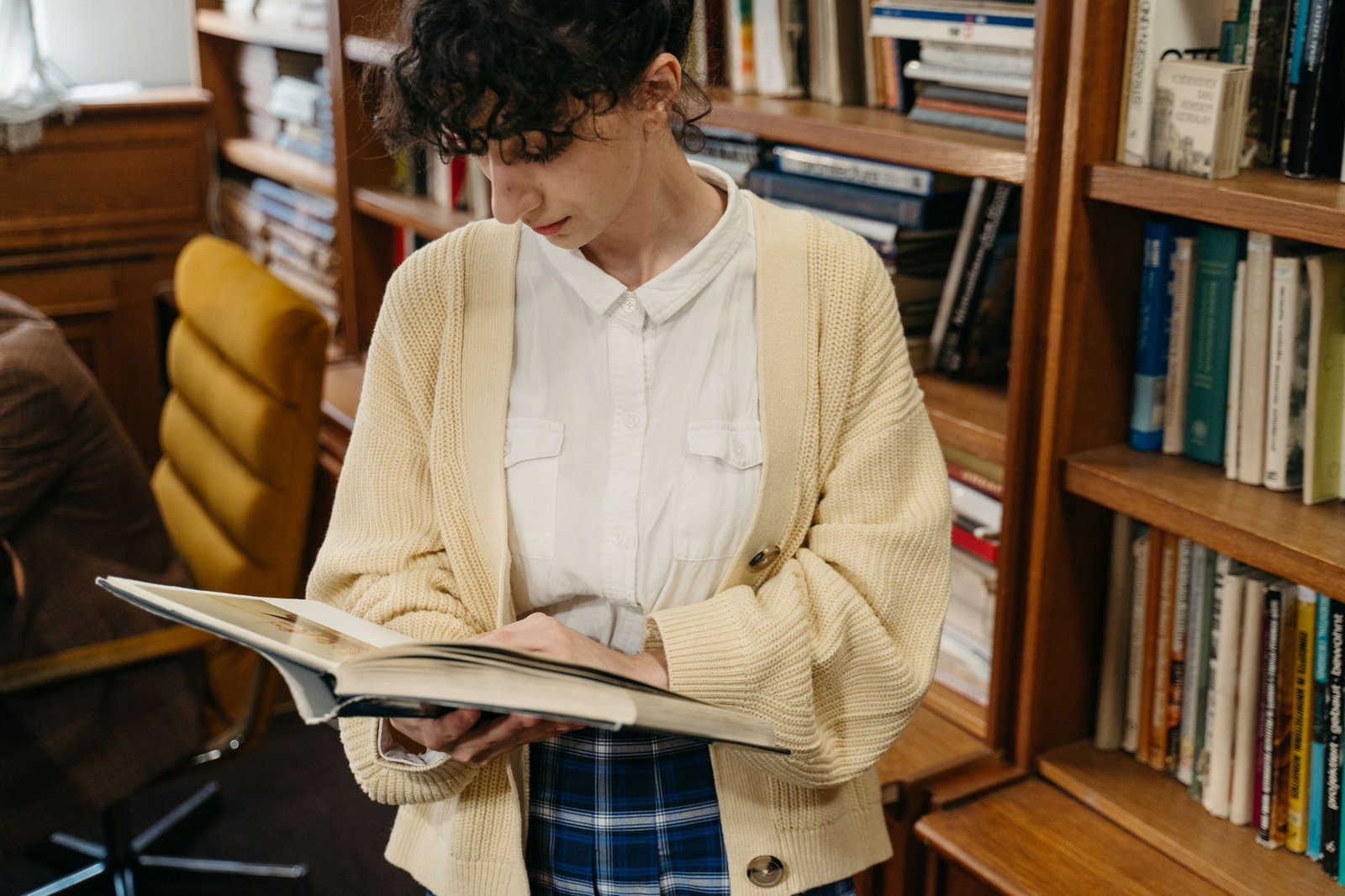 Preppy plaid skirt with cable-knit cardigan and collar visible